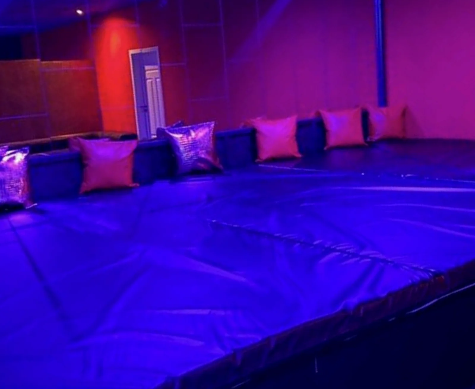 Große gepolsterte Spielwiese mit Kissen im violetten Licht